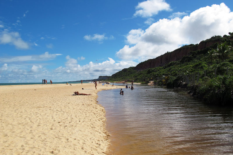 Rio que encontra o mar na praia de Pitinga