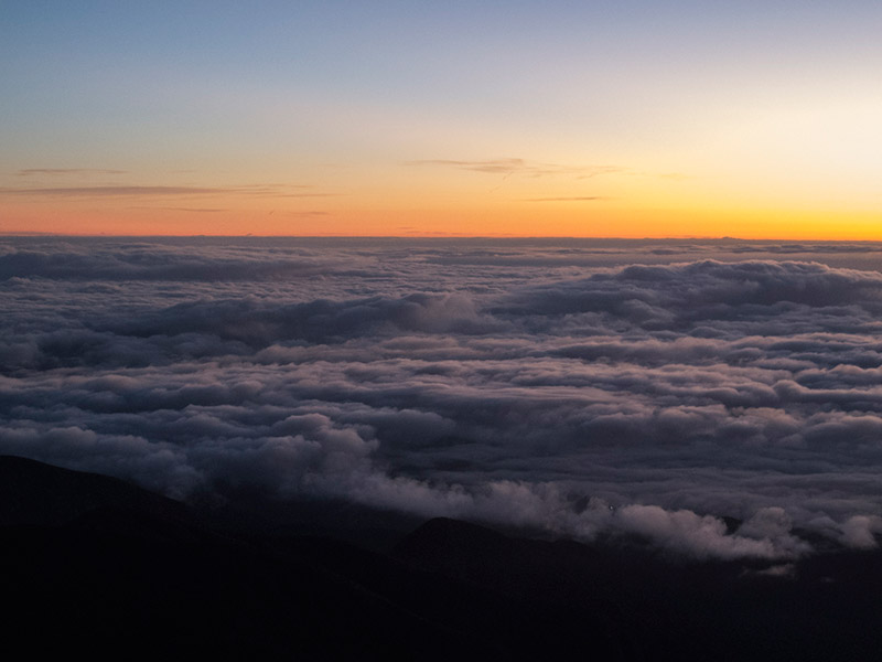 Vista do Pico da Bandeira no nascer do sol, cheio de nuvens